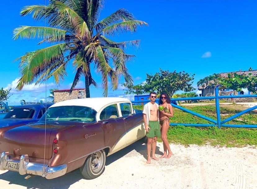 junges Paar vor Oldtimer auf Kuba
